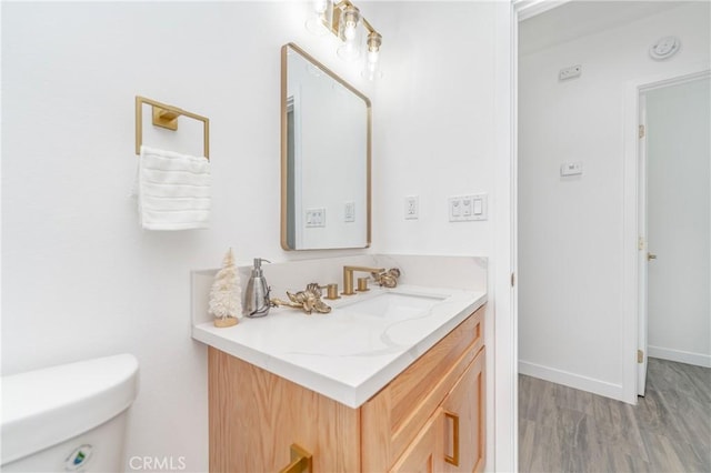 bathroom with vanity, wood-type flooring, and toilet