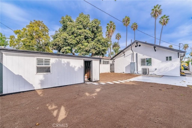 rear view of property with central AC unit and a patio area