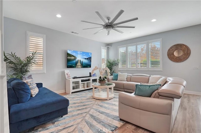 living room with light hardwood / wood-style floors and ceiling fan