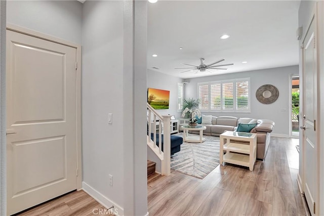 living room with light hardwood / wood-style floors and ceiling fan