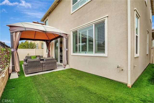 back of house featuring a gazebo, a lawn, and outdoor lounge area