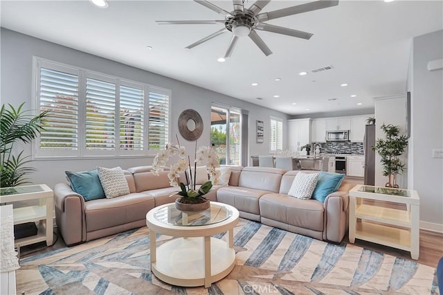 living room featuring ceiling fan and light hardwood / wood-style flooring