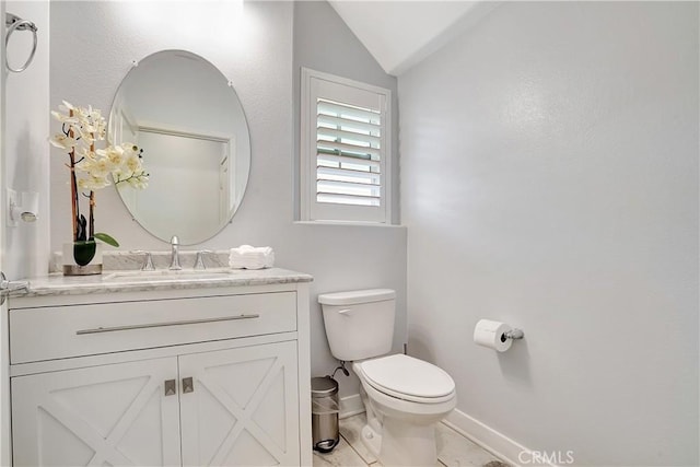 bathroom with lofted ceiling, toilet, and vanity