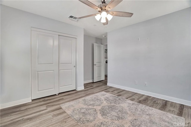 unfurnished bedroom with ceiling fan, a closet, and light hardwood / wood-style flooring