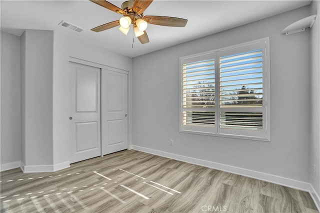 unfurnished bedroom with ceiling fan, light hardwood / wood-style floors, and a closet