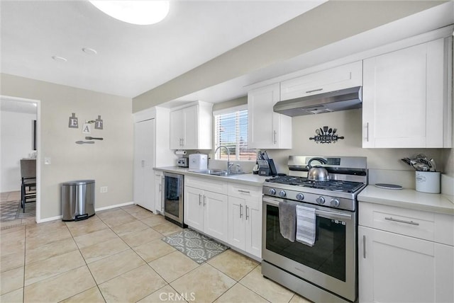 kitchen featuring sink, white cabinetry, stainless steel range with gas cooktop, and exhaust hood