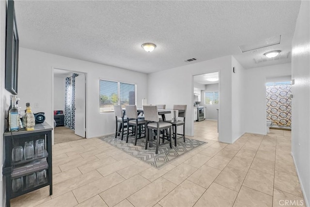 dining space with light tile patterned floors and a textured ceiling