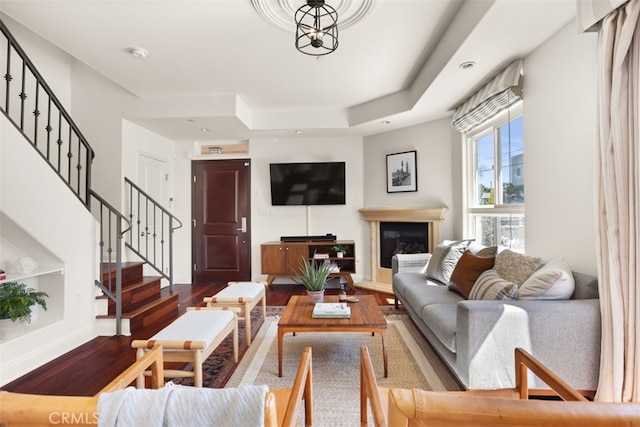 living room featuring hardwood / wood-style floors and a tray ceiling