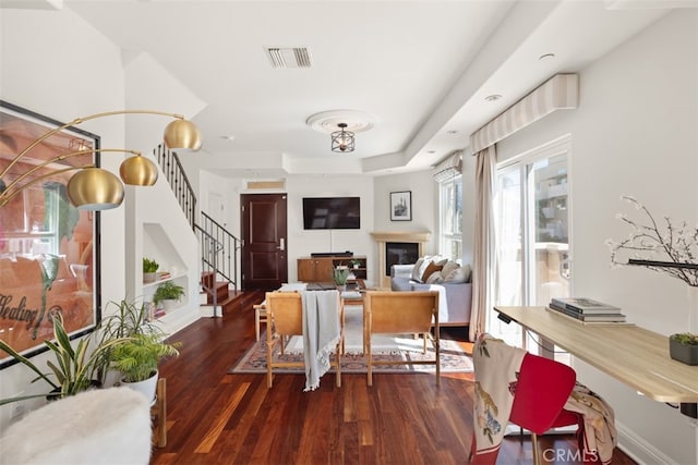 dining space featuring a raised ceiling and dark hardwood / wood-style flooring