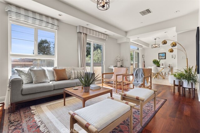 living room featuring dark hardwood / wood-style flooring and a chandelier