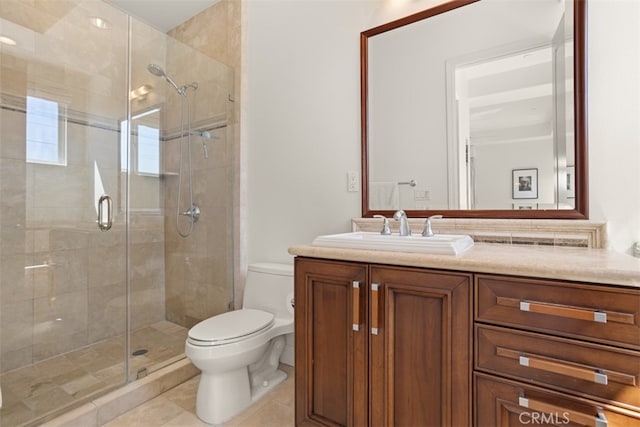 bathroom featuring tile patterned floors, vanity, toilet, and a shower with door