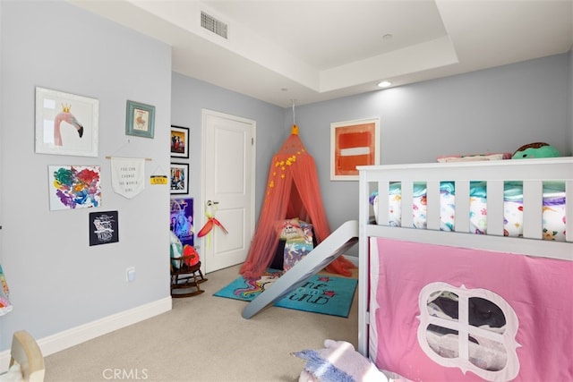 bedroom featuring a raised ceiling and carpet