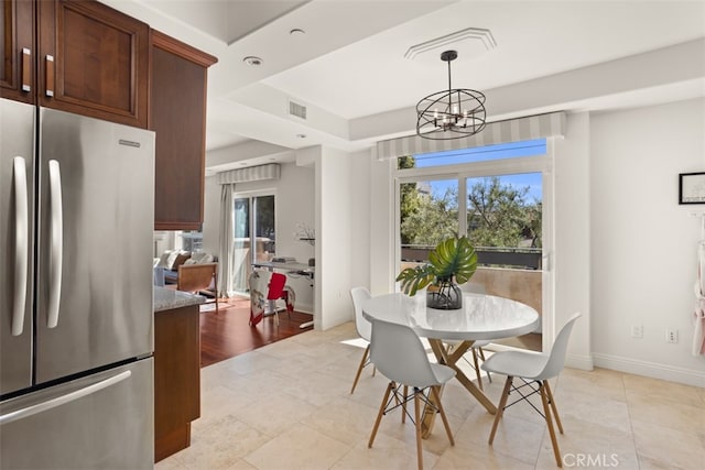 dining area with a wealth of natural light, light hardwood / wood-style flooring, and a chandelier