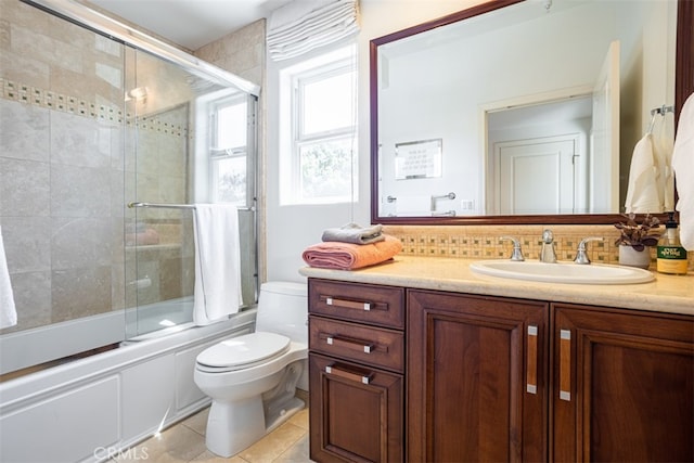 full bathroom with tasteful backsplash, tile patterned flooring, enclosed tub / shower combo, toilet, and vanity