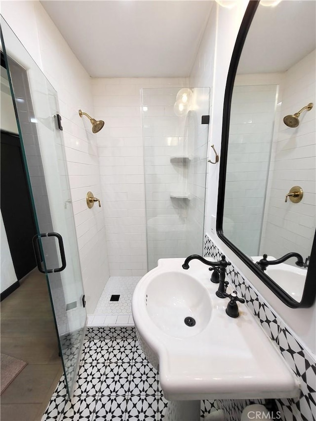 bathroom with tile patterned flooring, an enclosed shower, and sink