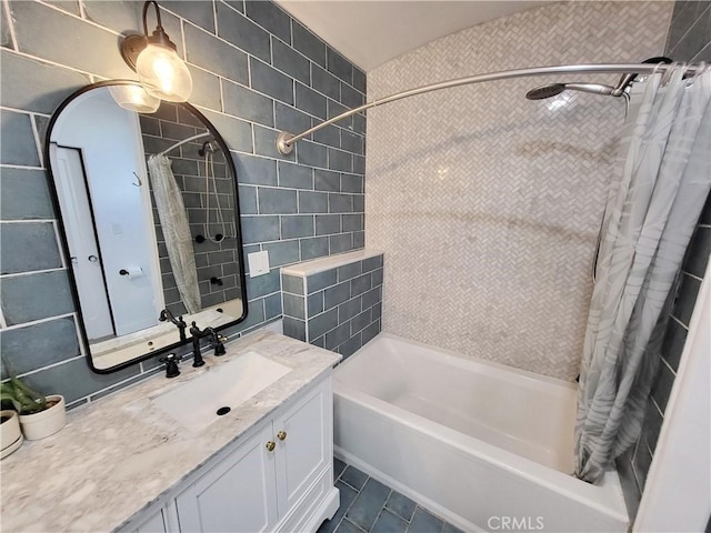 bathroom with vanity, tile patterned floors, tile walls, and shower / bath combo with shower curtain