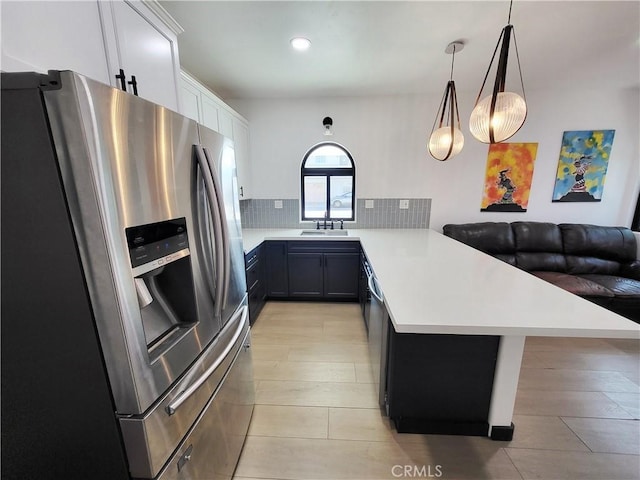 kitchen featuring white cabinetry, hanging light fixtures, kitchen peninsula, a breakfast bar area, and appliances with stainless steel finishes