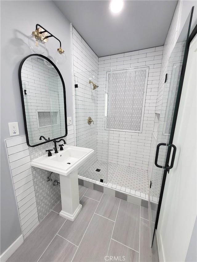 bathroom featuring tile patterned flooring, tile walls, and walk in shower