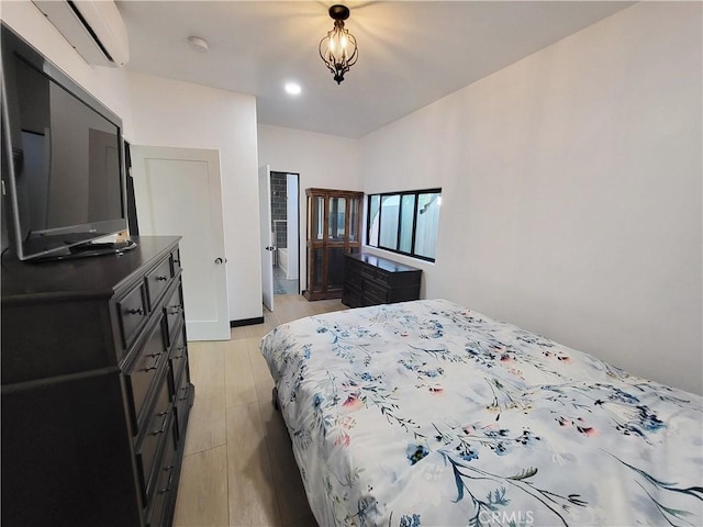 bedroom with light wood-type flooring and a wall unit AC