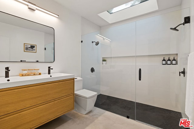 bathroom with vanity, toilet, a shower with shower door, and a skylight