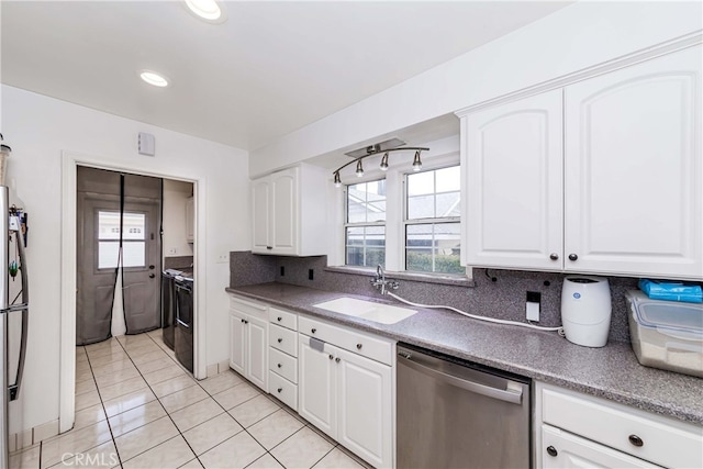 kitchen featuring white cabinets, sink, decorative backsplash, light tile patterned floors, and appliances with stainless steel finishes