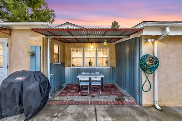 patio terrace at dusk featuring grilling area