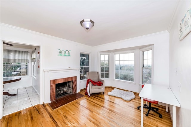 sitting room with a fireplace, wood-type flooring, and ornamental molding