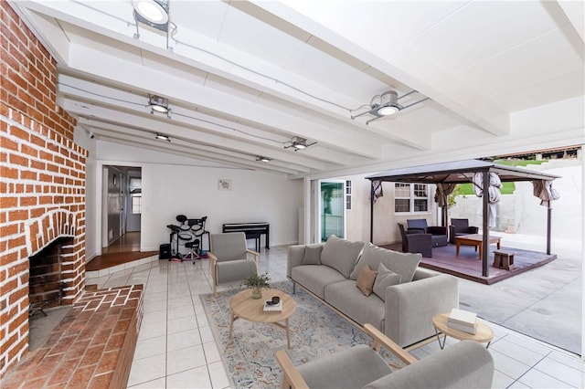 living room with beam ceiling, light tile patterned floors, and a brick fireplace