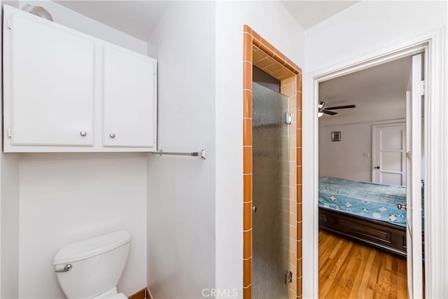 bathroom featuring hardwood / wood-style flooring, toilet, and ceiling fan