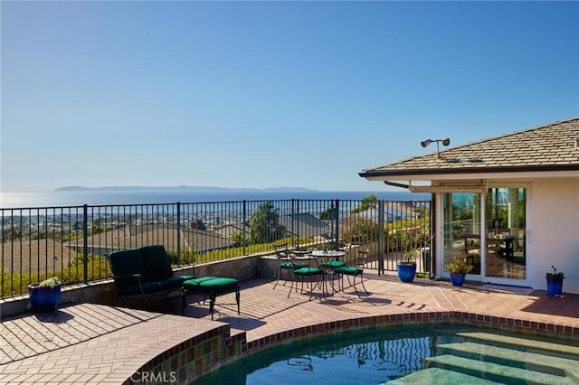 view of pool with a patio and a water view