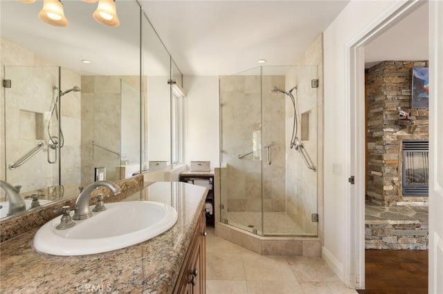 bathroom featuring tile patterned flooring, vanity, a stone fireplace, and walk in shower