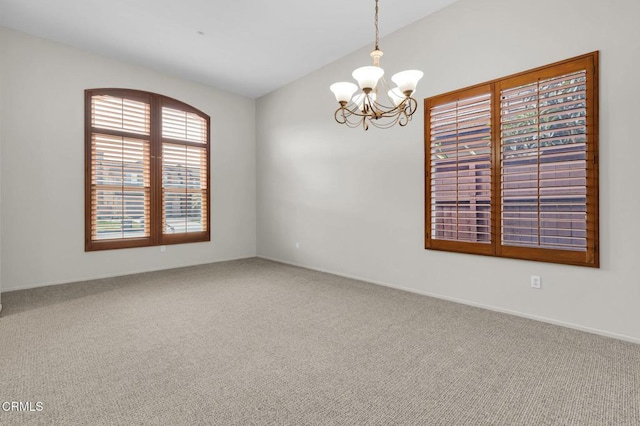 unfurnished room with vaulted ceiling, carpet flooring, and an inviting chandelier