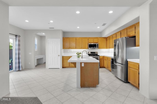 kitchen with a center island with sink, light tile patterned floors, stainless steel appliances, recessed lighting, and light countertops