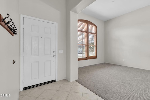 foyer featuring light tile patterned floors and light colored carpet