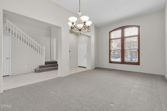 interior space featuring a chandelier, carpet, tile patterned flooring, and stairs