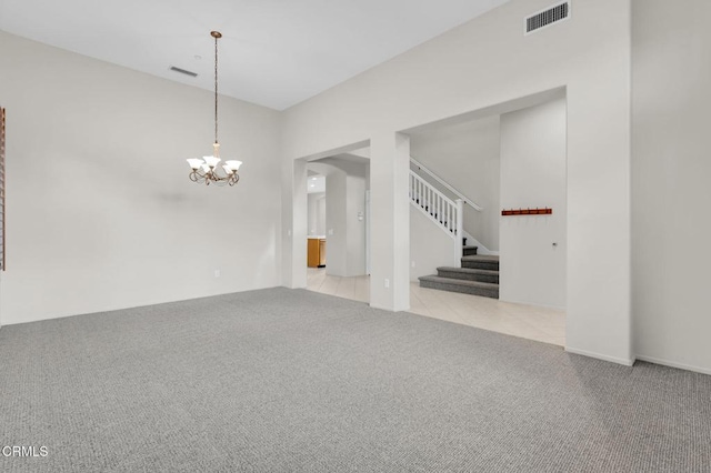 carpeted spare room featuring stairway, visible vents, a notable chandelier, and tile patterned floors