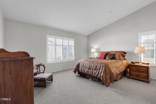 bedroom featuring multiple windows, baseboards, vaulted ceiling, and light colored carpet