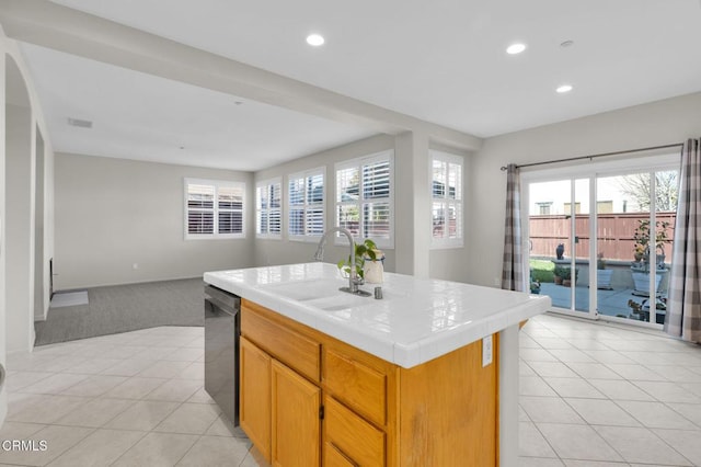 kitchen featuring tile countertops, dishwashing machine, recessed lighting, a sink, and open floor plan