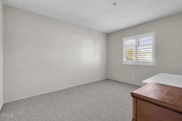 unfurnished room featuring baseboards and carpet flooring