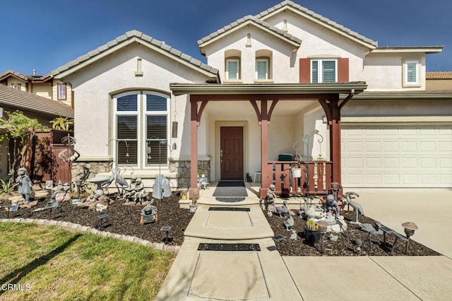 mediterranean / spanish home featuring stone siding, driveway, a tiled roof, and stucco siding