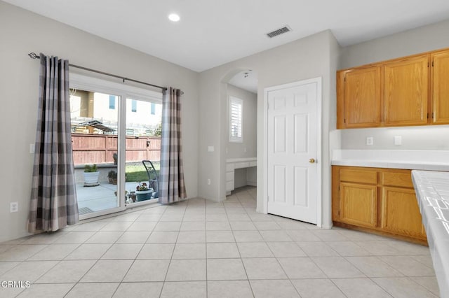 kitchen featuring arched walkways, tile countertops, light tile patterned floors, recessed lighting, and visible vents