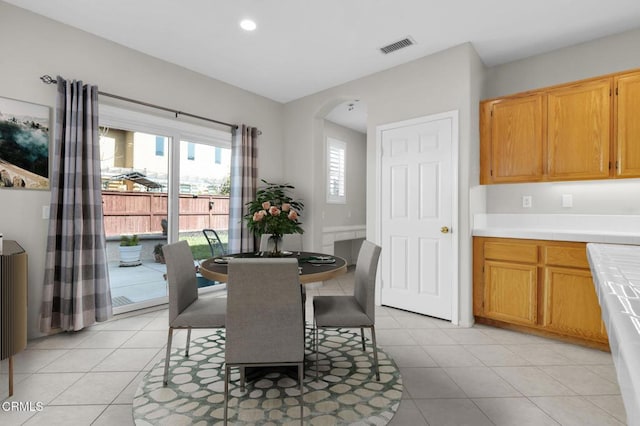 dining area featuring arched walkways, visible vents, recessed lighting, and light tile patterned floors