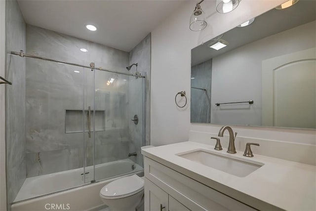 full bathroom featuring toilet, bath / shower combo with glass door, and vanity