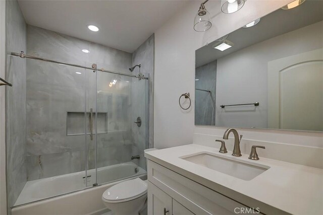 full bathroom with vanity, enclosed tub / shower combo, and toilet