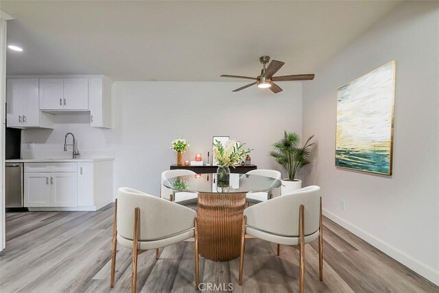 dining space with ceiling fan, sink, and light hardwood / wood-style floors