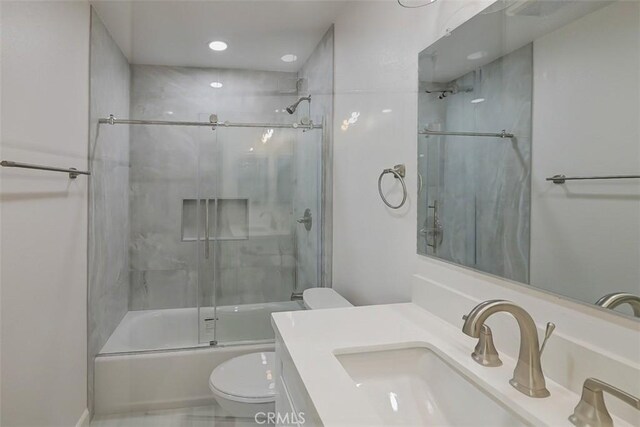 full bathroom with vanity, combined bath / shower with glass door, and toilet