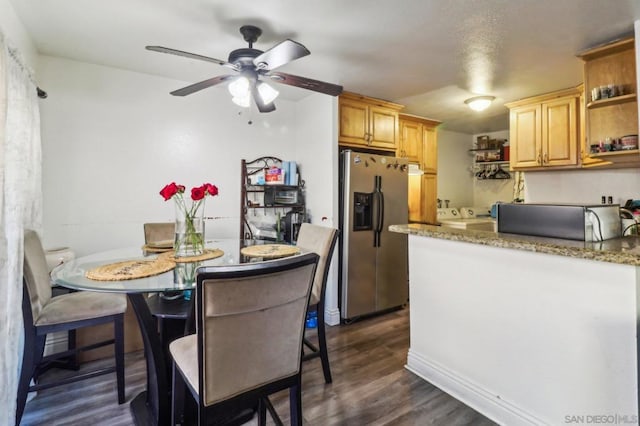 kitchen featuring light stone countertops, stainless steel fridge with ice dispenser, ceiling fan, and dark wood-type flooring