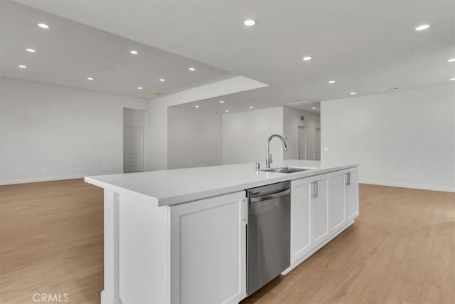 kitchen with white cabinetry, stainless steel dishwasher, sink, and an island with sink