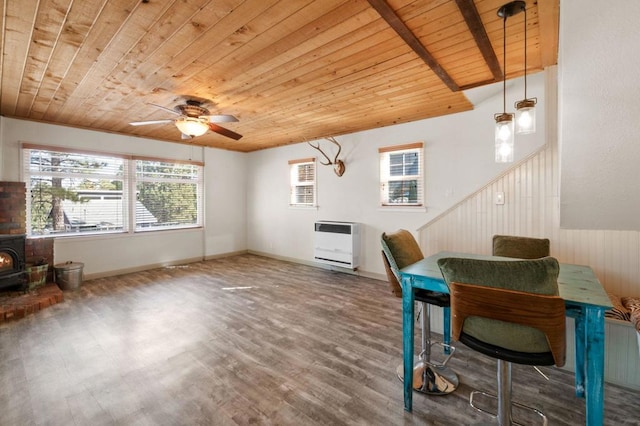 office space with heating unit, wood-type flooring, wood ceiling, and a wood stove