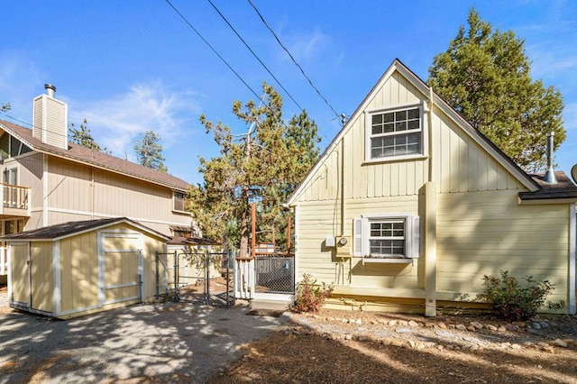 rear view of house featuring a storage shed